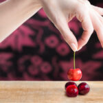 Female hand selecting a cherry